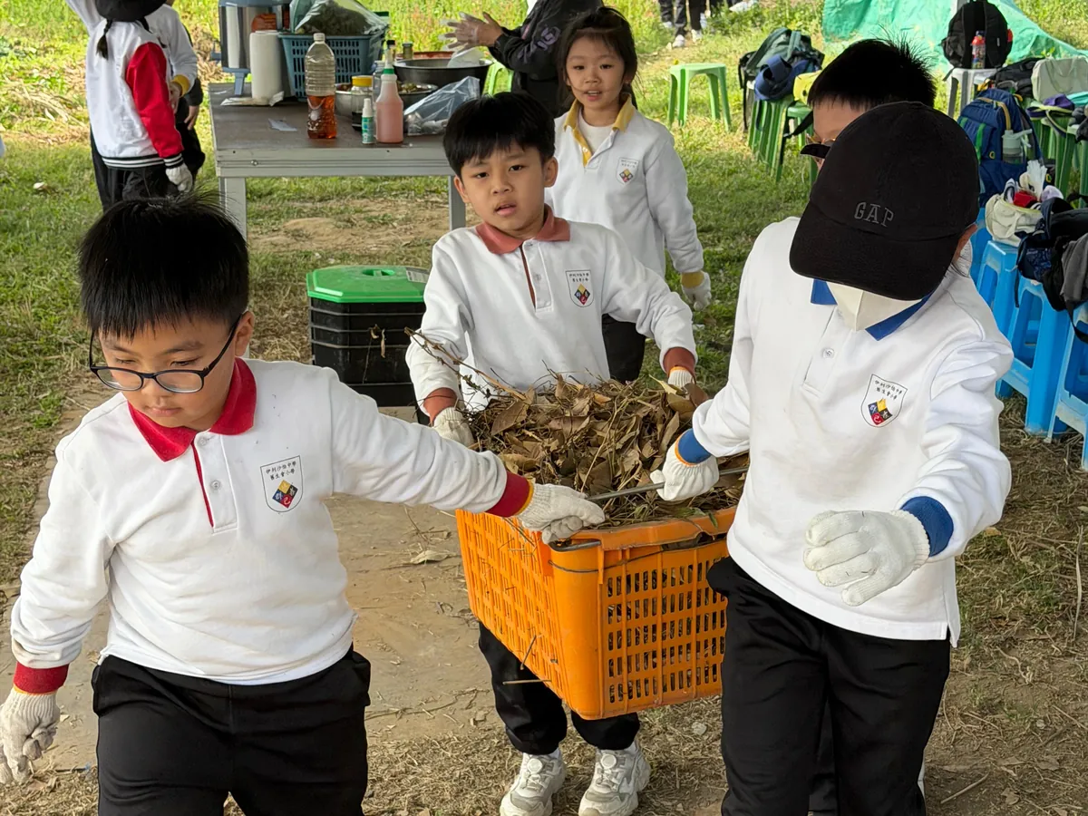 Primary students carrying food scraps to the field on a Table-to-Farm day