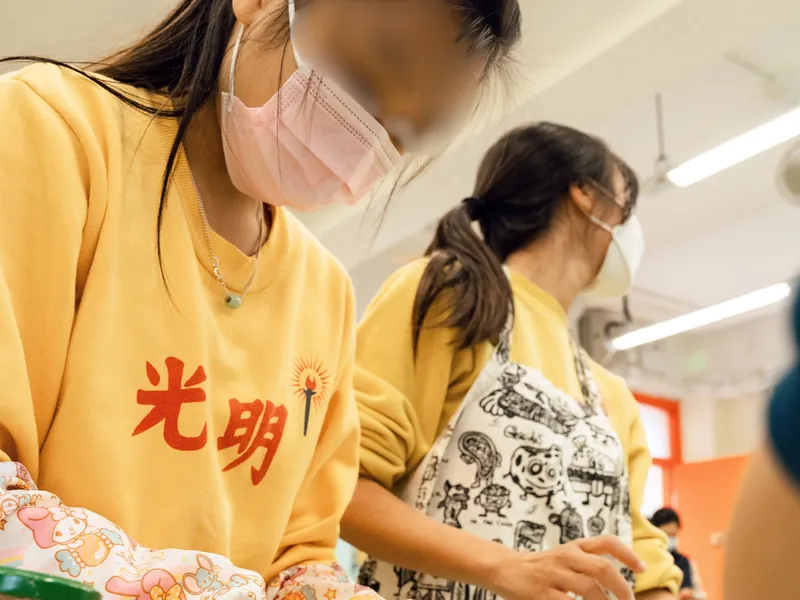 Students topping pizzas with ugly produce
